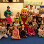 Children sitting with elf.